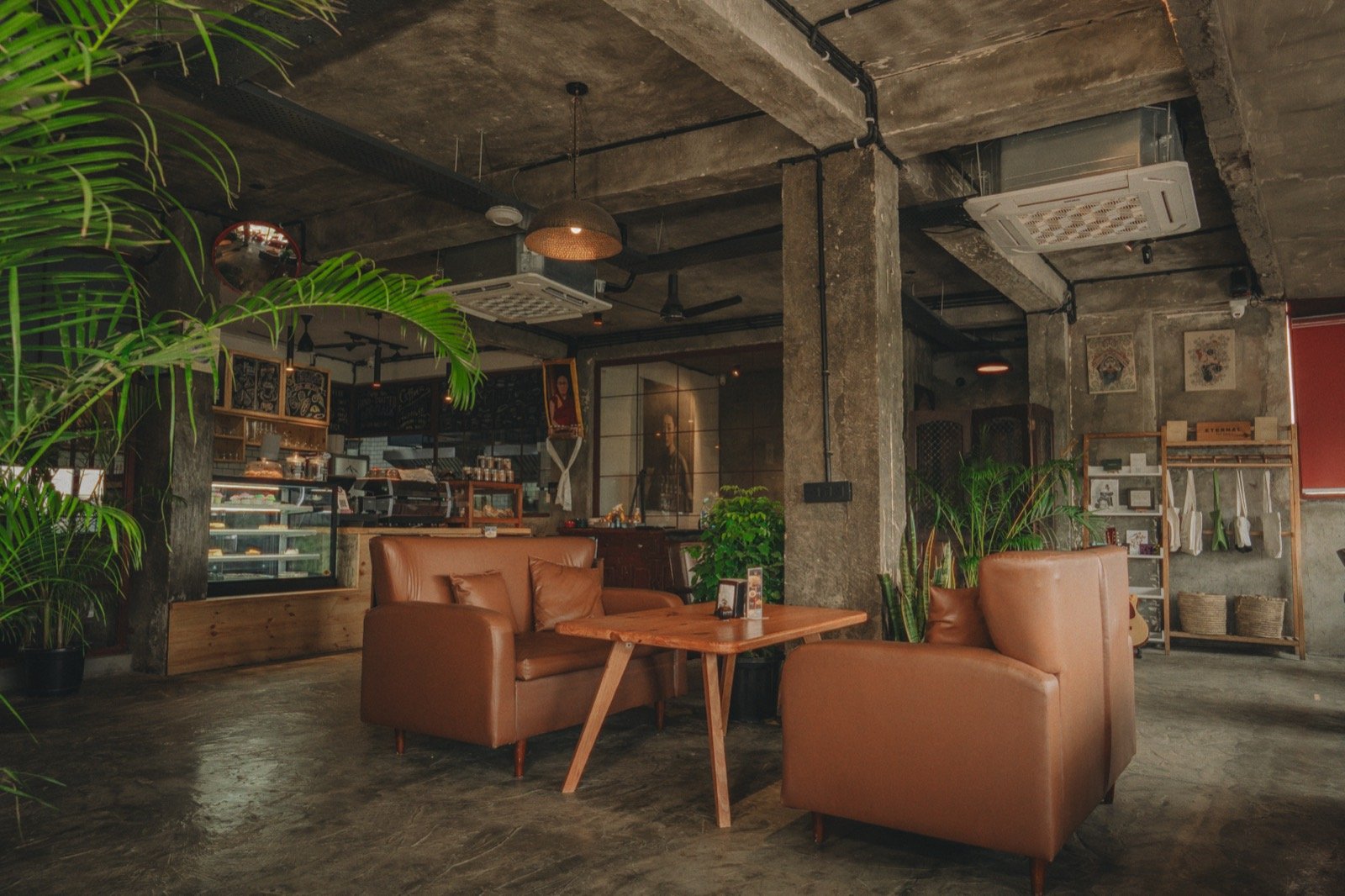 Cognac leather sofas and a wooden table among palms