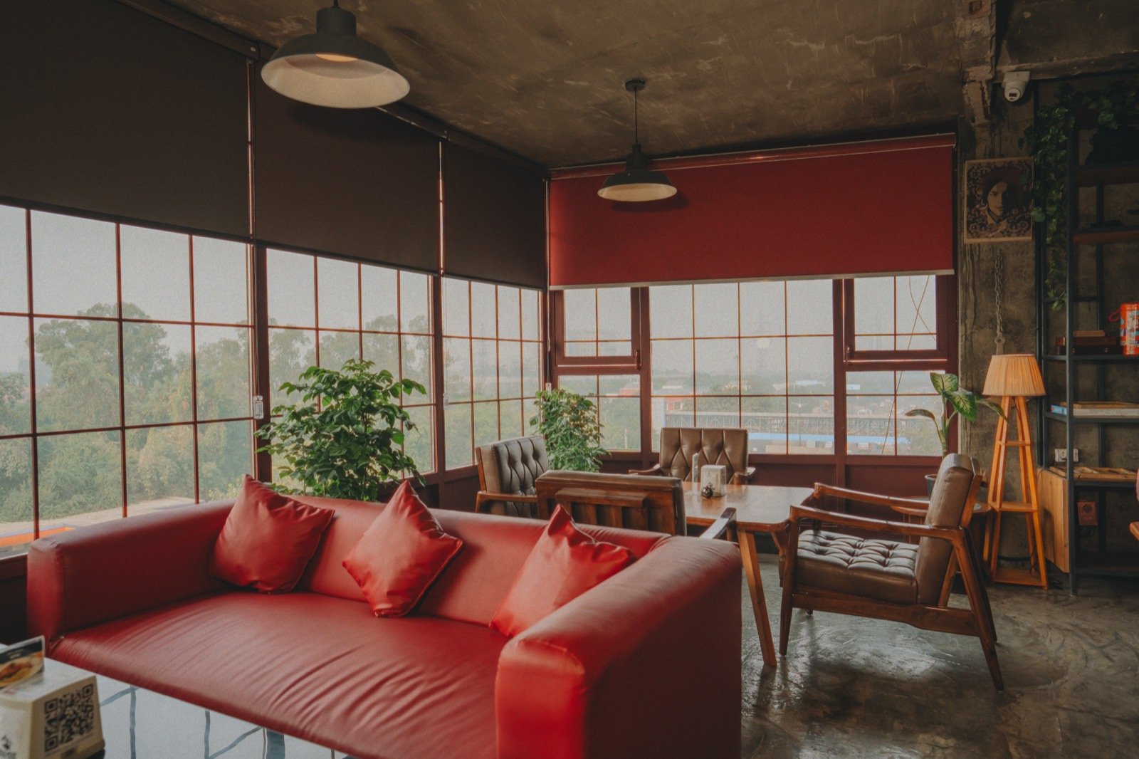 Long red leather sofa with red cushions in front of a wall of windows