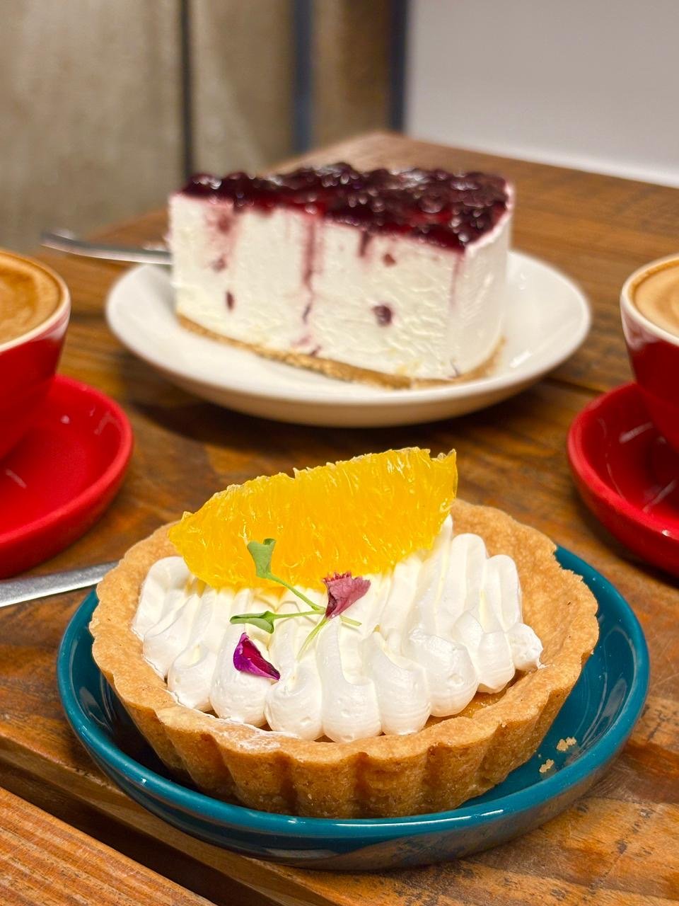 Citrus cream tart and blueberry cheesecake with two lattes